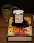 Candle labeled 'Diem' on a book titled 'Glow of the Ever Flame' with a blurred background