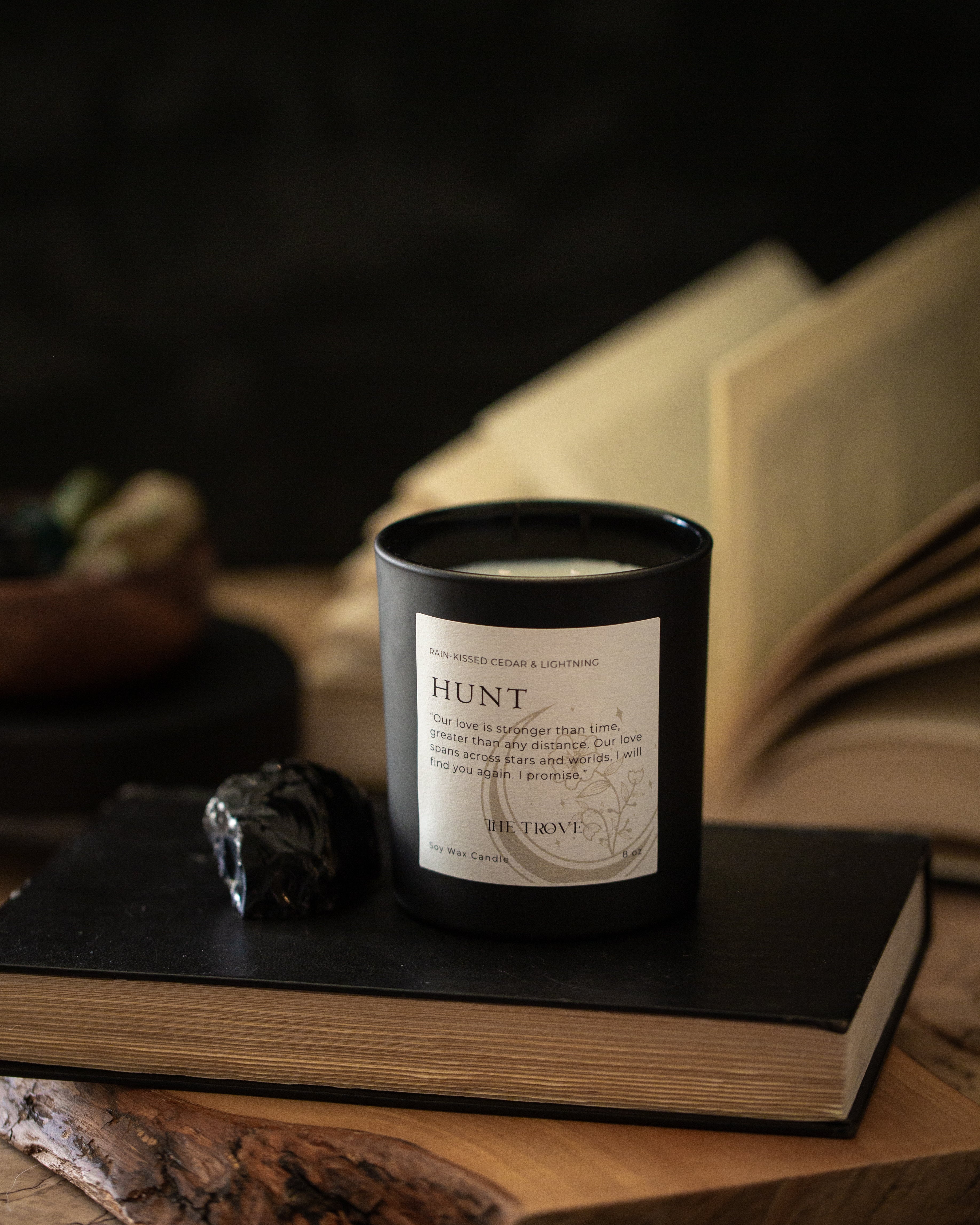Candle labeled 'Hunt' on a book with a dark background