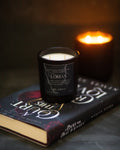 Candle labeled 'Lorian' on a book with another candle in the background