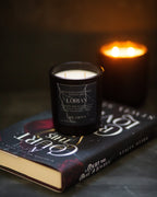 Candle labeled 'Lorian' on a book with another candle in the background
