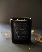 Black candle with white text on a dark background