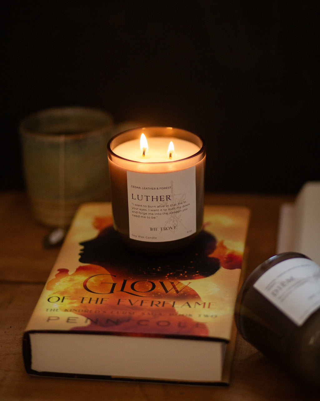 Candle with a label on top of a book in a dark setting