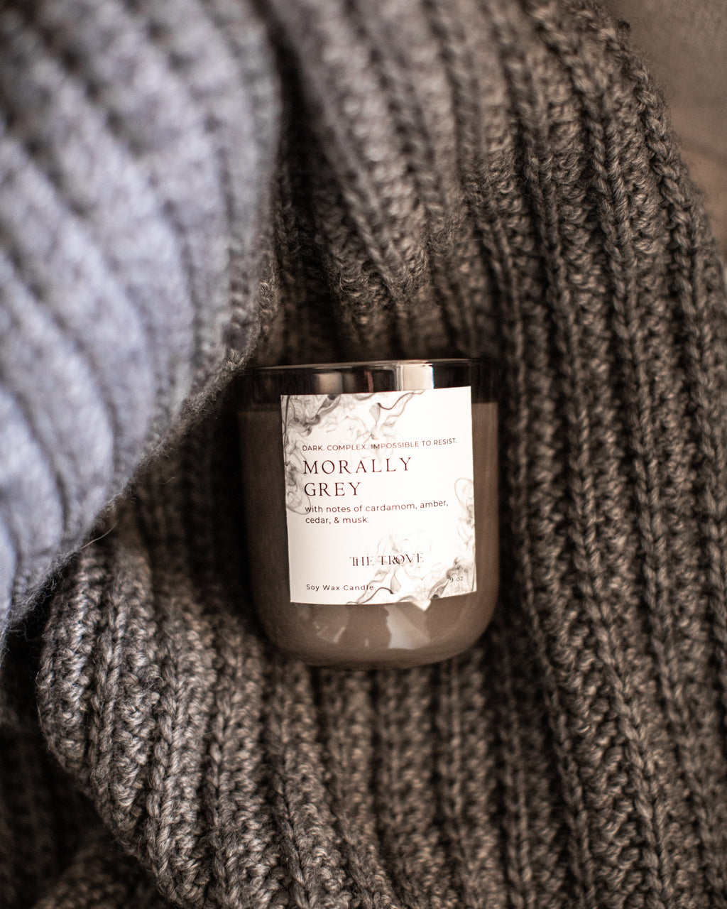 Candle labeled 'Morally Grey' wrapped in a textured fabric