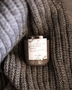 Candle labeled 'Morally Grey' wrapped in a textured fabric
