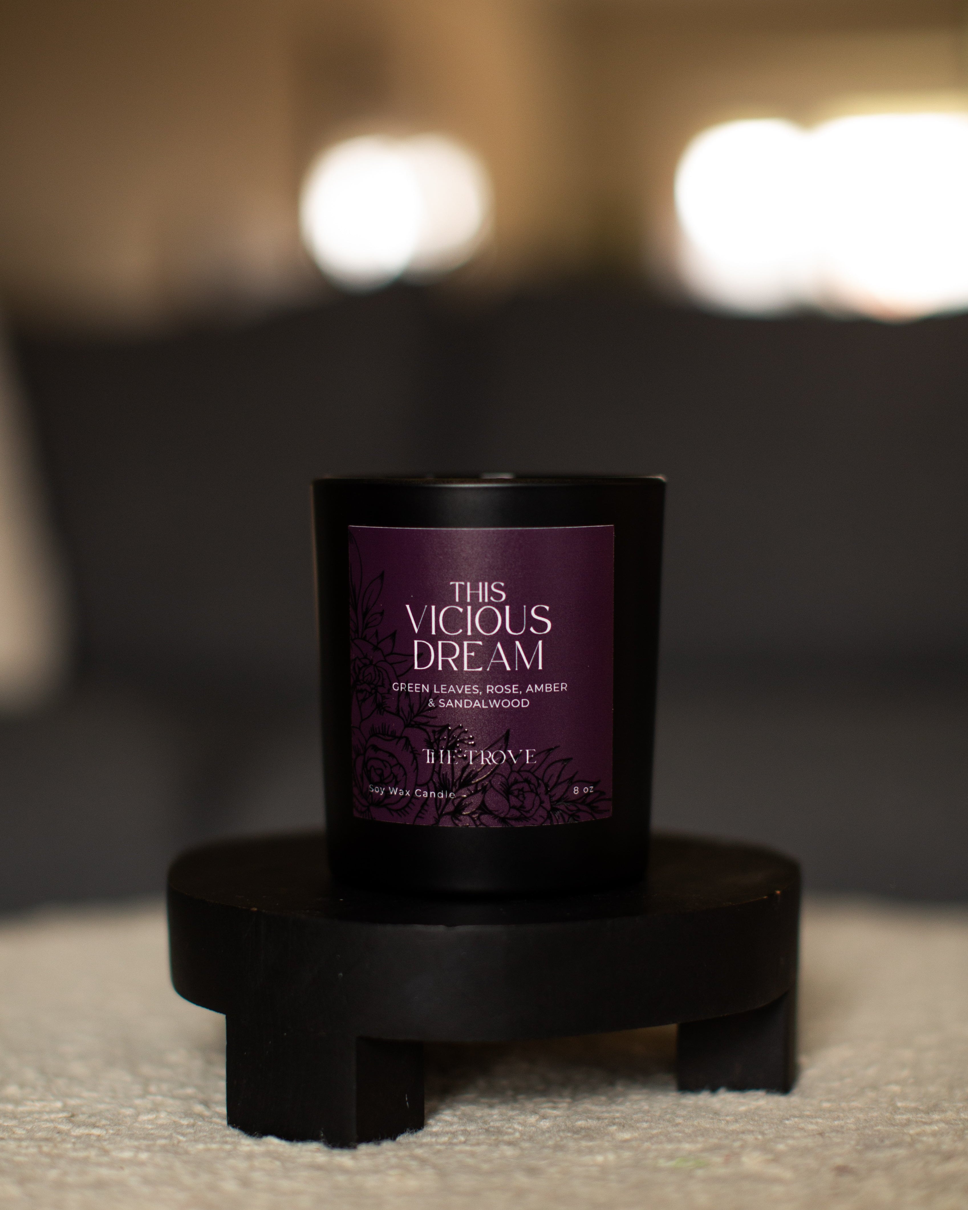 Candle labeled 'This Vicious Dream' on a stand with a blurred background