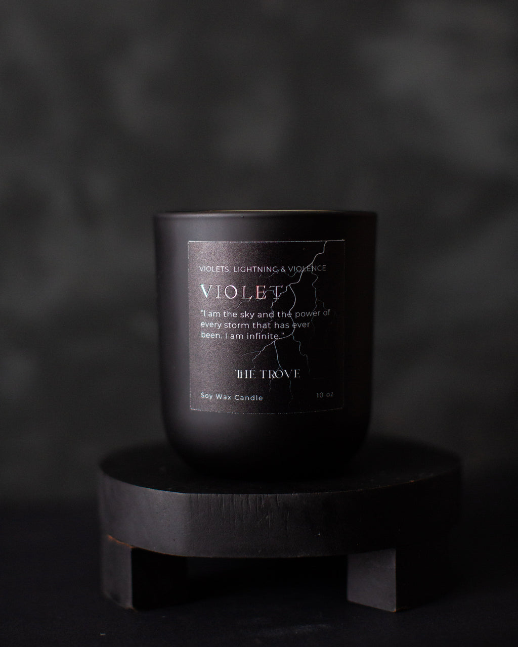 Black candle labeled 'VIOLET' on a dark background