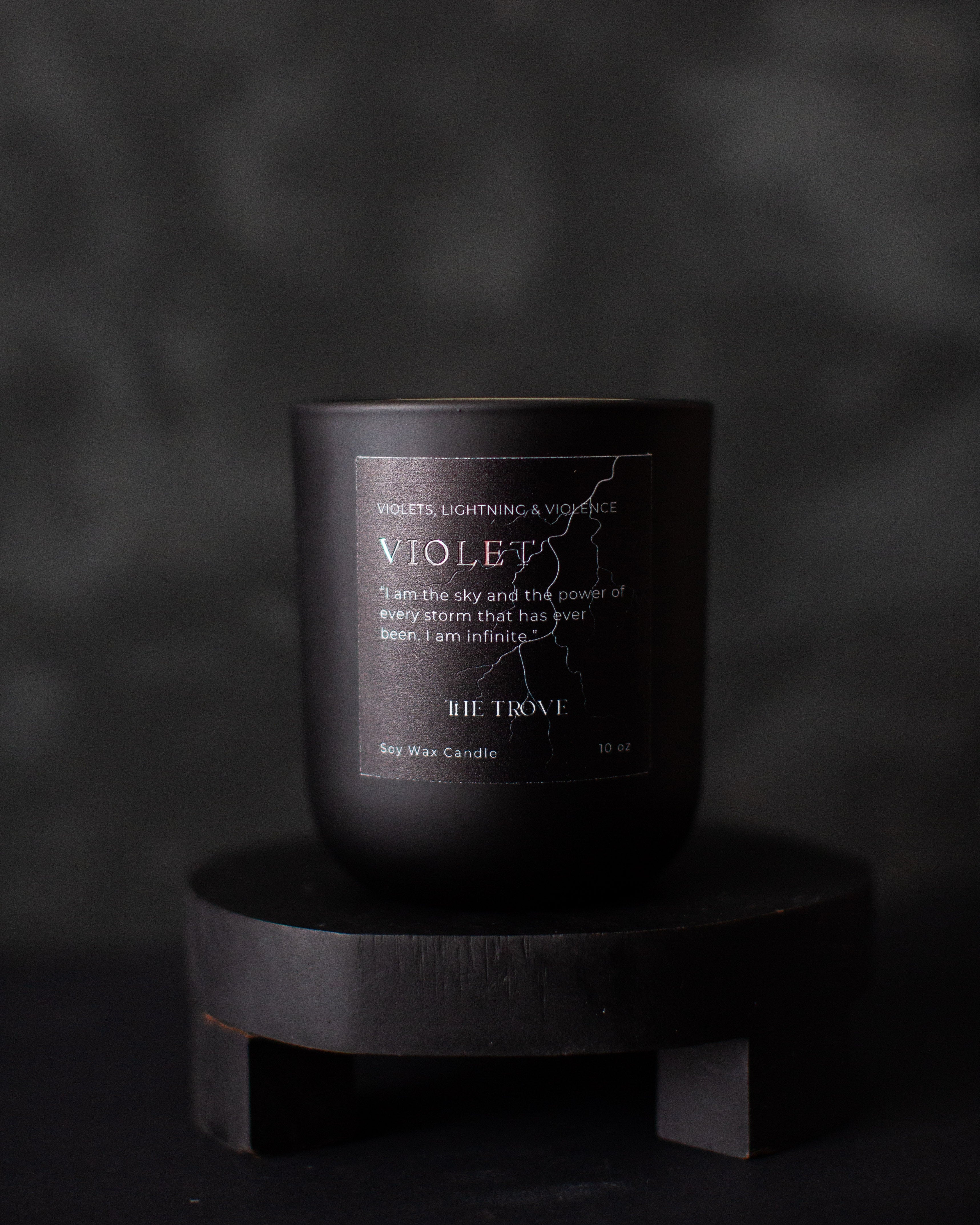 Black candle labeled 'VIOLET' on a dark background