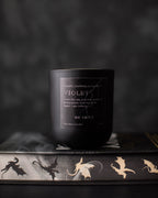 Black candle with a label on a dark background