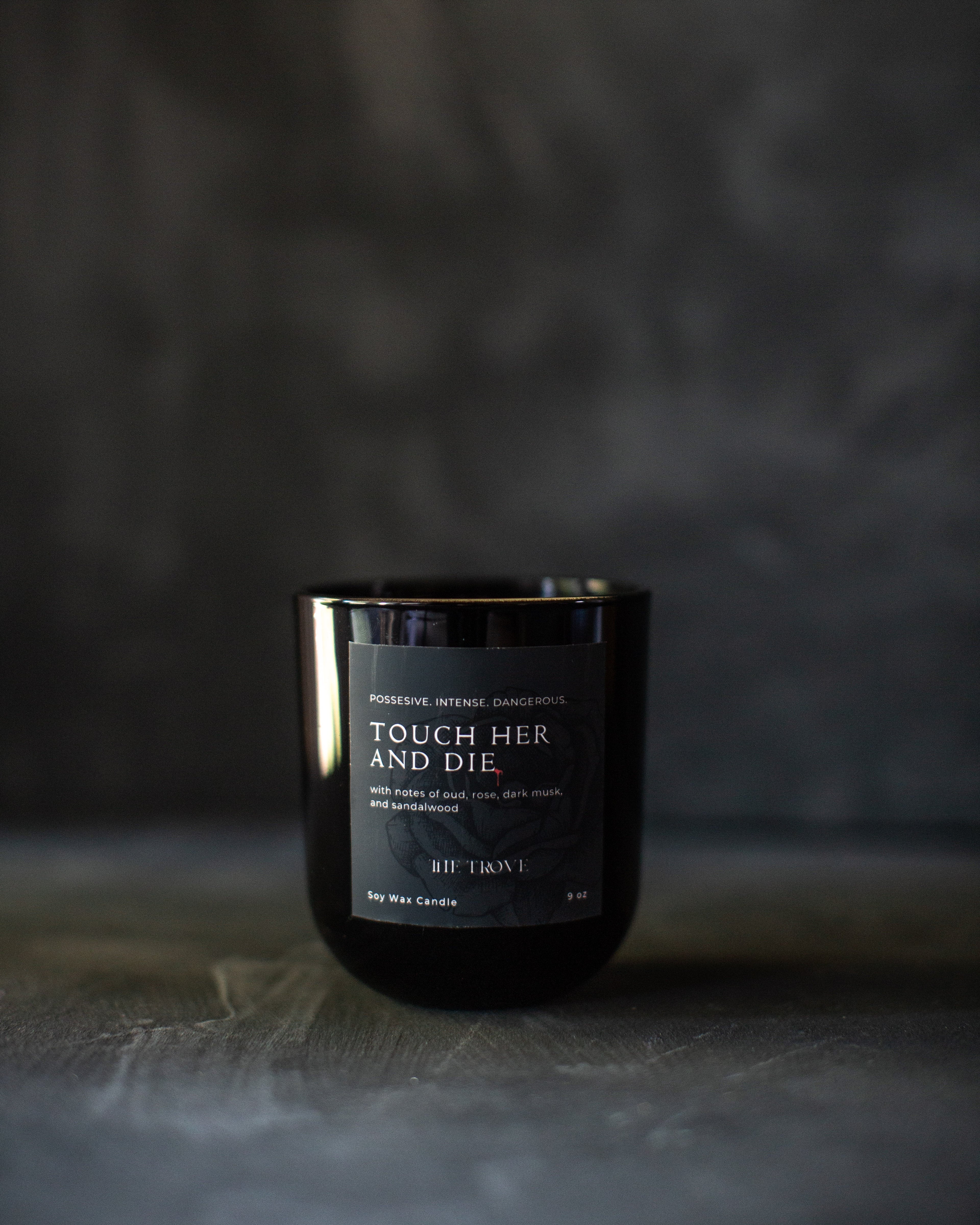 Black candle with a label on a dark background